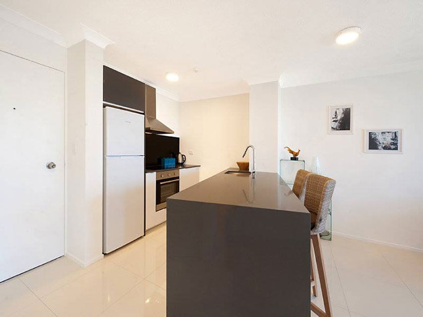 Designer kitchen redesigned to incorporate the old linen closet as a pantry, resulting in the peninsula being angled.