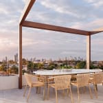 Rooftop terrace at UNIQ Residences Gold Coast featuring panoramic city and water views, stylish outdoor seating, lush greenery, and a seamless indoor–outdoor connection.
