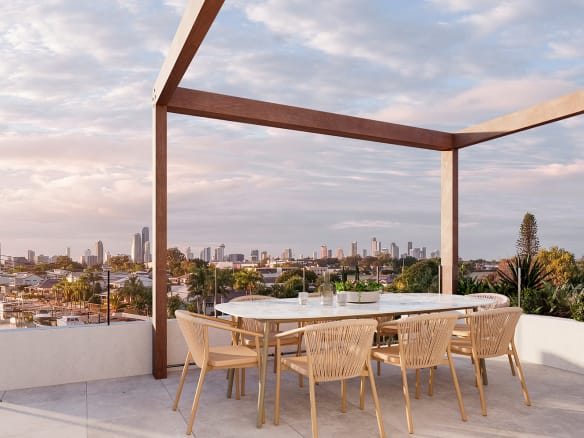 Rooftop terrace at UNIQ Residences Gold Coast featuring panoramic city and water views, stylish outdoor seating, lush greenery, and a seamless indoor–outdoor connection.