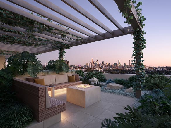 Designer rooftop BBQ area at Vera Apartments in Wooloowin, featuring a cosy firepit, lush greenery, built-in timber seating, and panoramic Brisbane city views at sunset.